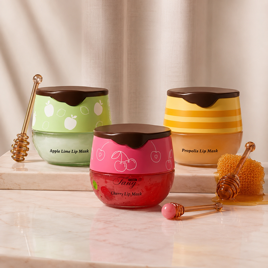 Three overnight lip mask jars on a marble surface, with a honey dipper alongside